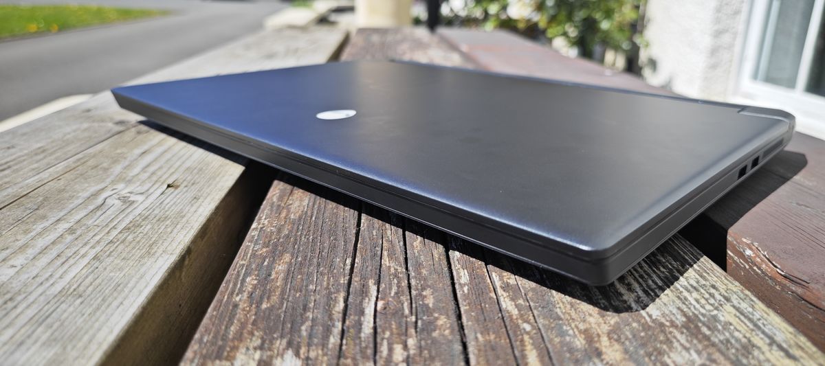 A dark grey Alienware m17 R5 gaming laptop sitting on a wooden table