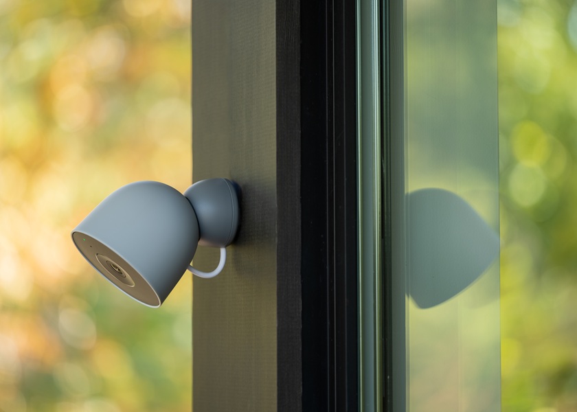 The new Google Nest Outdoor camera, mounted on a wall in its hazel color option.