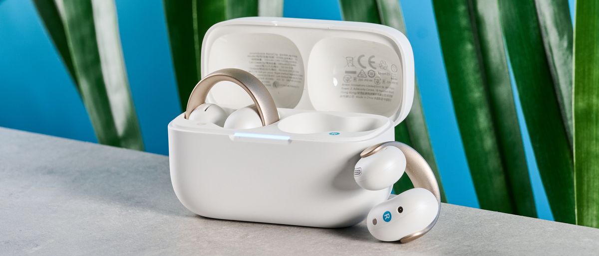 Soundcore AeroClip open-ear earbuds in champagne mist against a blue backdrop 