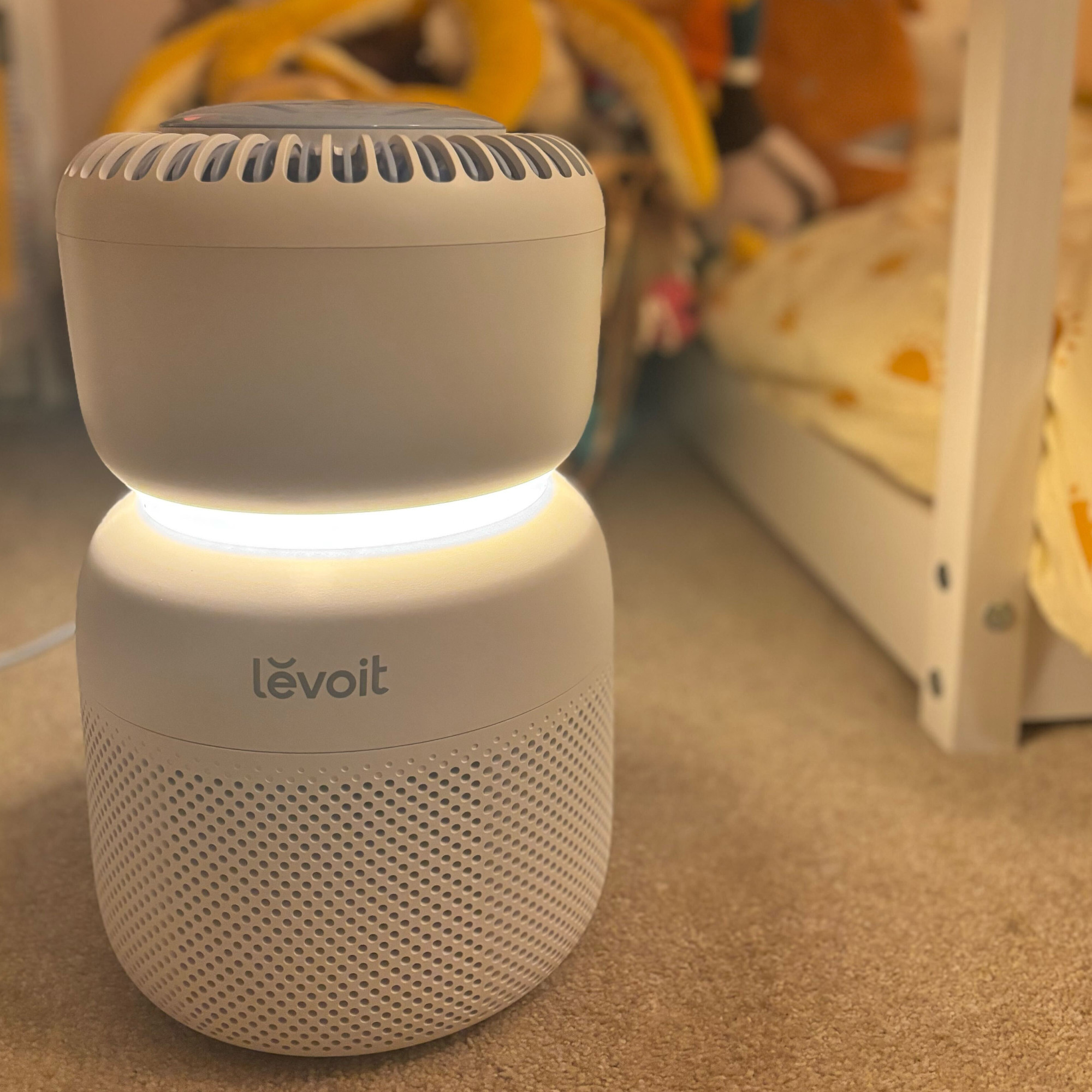 levoit sprout air purifier by a bed on carpet in a kid's bedroom