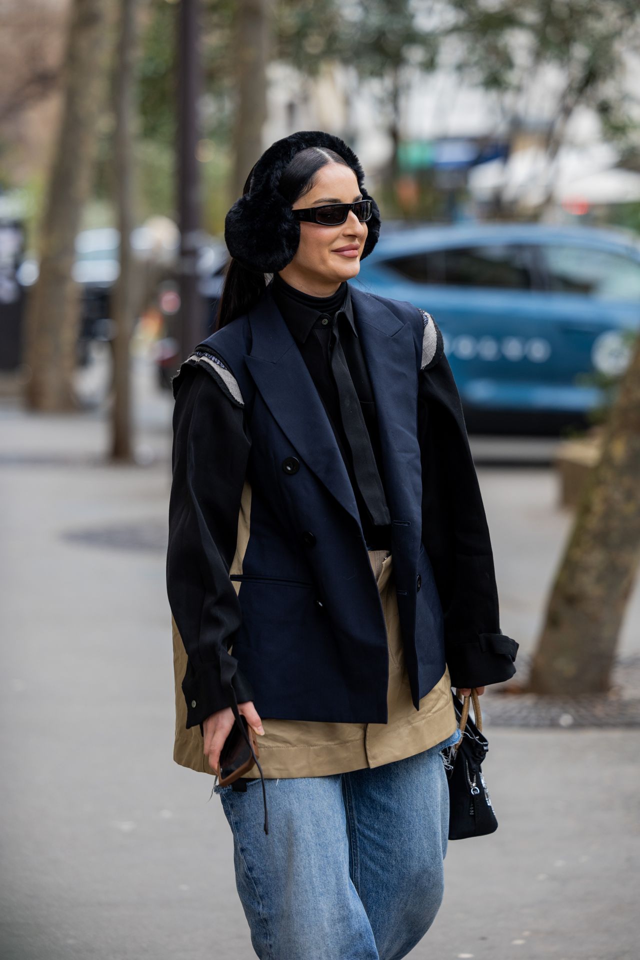 PARIS, FRANCE - JANUARY 22: Fiona Zanetti wears ripped denim jeans, ear warmer, navy sleeveless blazer, black button shirt, tie outside Sacai during Paris Fashion Week - Menswear Fall-Winter 2023-2024 on January 22, 2023 in Paris, France. (Photo by Christian Vierig/Getty Images)