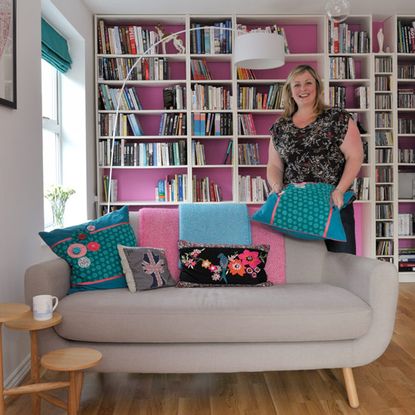 sofa with cushion and living room with books shelves and floor lamp