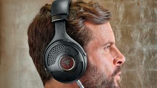 Focal Utopia over-ears being worn by a man, on beige background