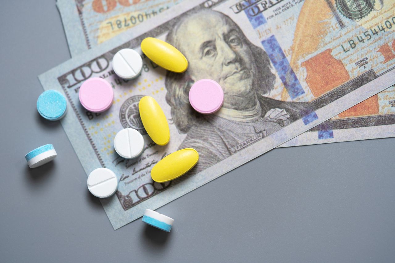 Image of a variety of pills on top of a $100 bill.