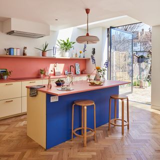 Open plan colourful kitchen with island and Scandi cupboards.
