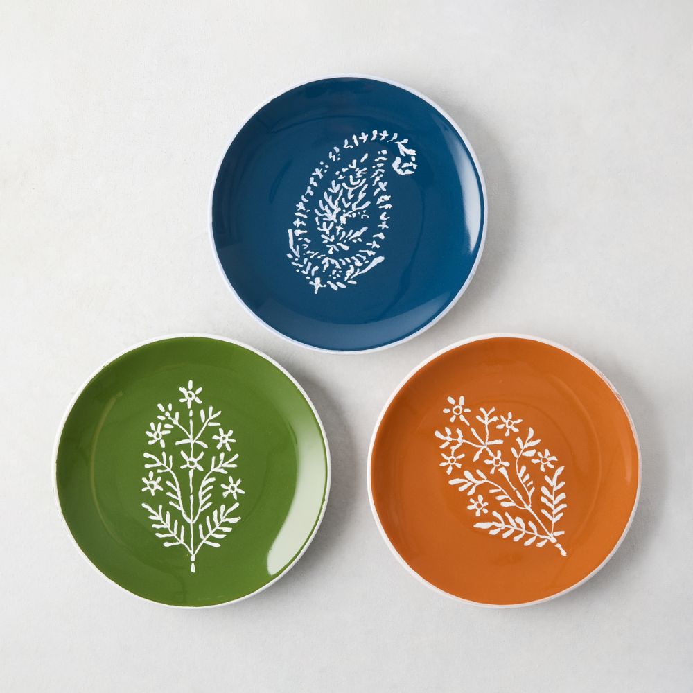 Three appetizer plates in green, orange and blue
