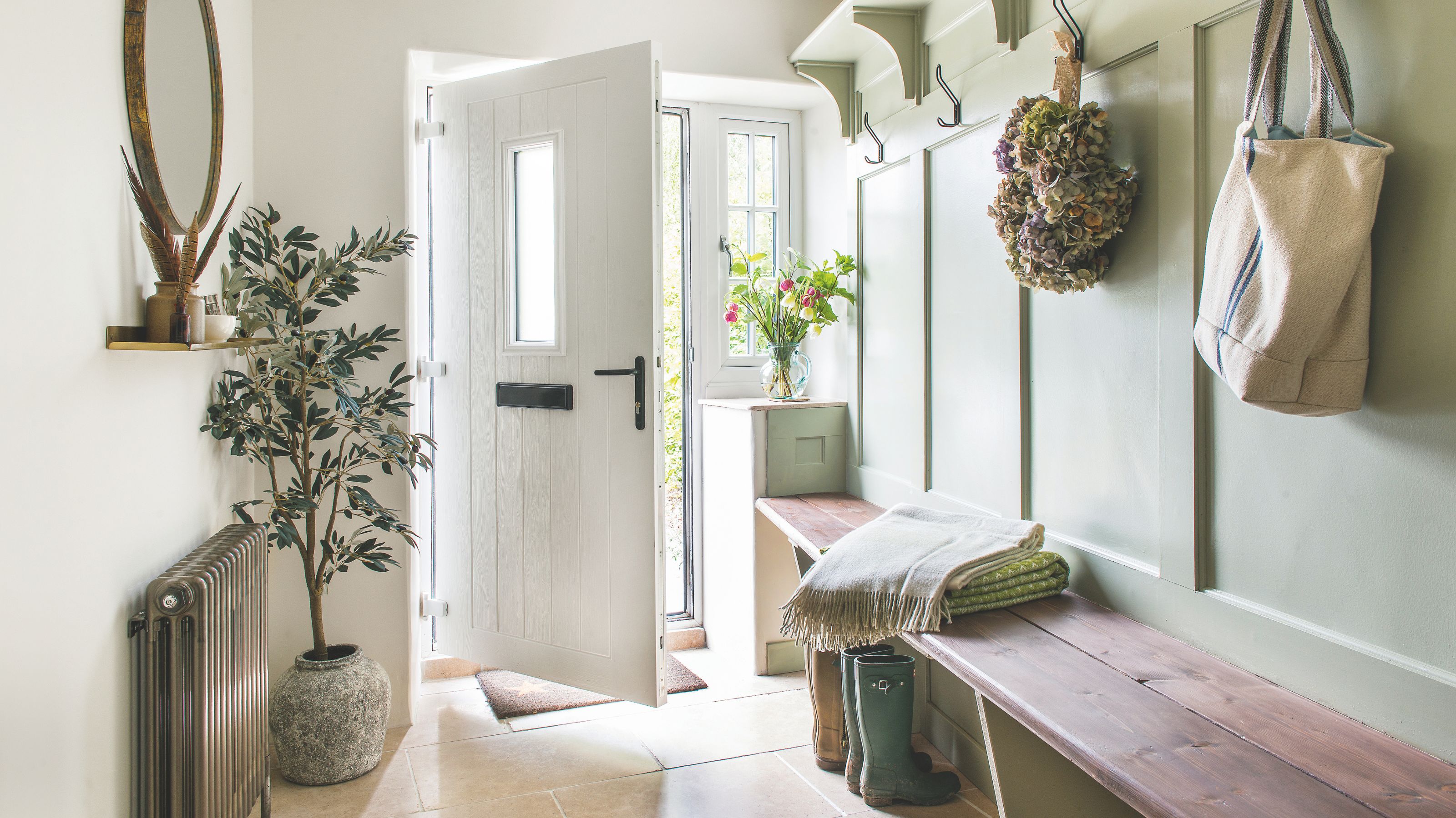 Hallway with storage bench and panelling on one side, and a radiator and plant on the other