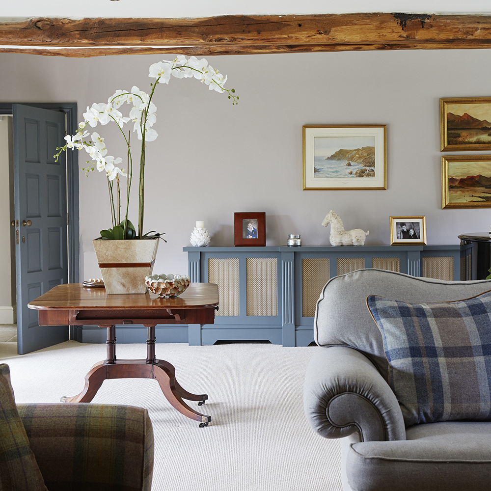 living area with white wall with pictures and grey sofa with cushions
