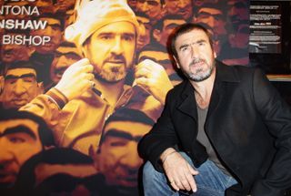 Eric Cantona poses in front of a poster for the film Looking for Eric in Berlin in October 2009.