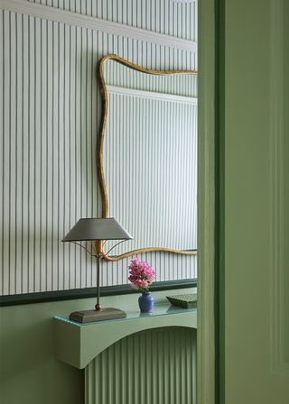 green entryway with large mirror