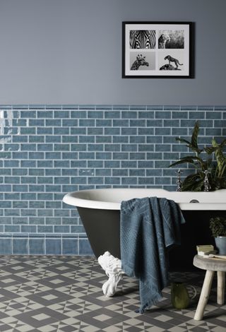 patterned floor tiles in bathroom with roll top bath