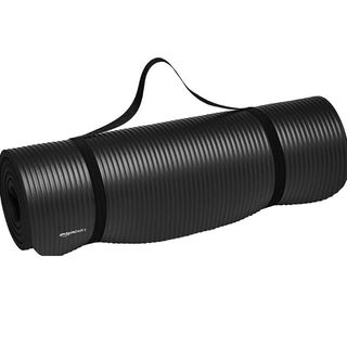 A product image of a rolled up black yoga mat