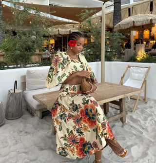 Woman wears a Farm Rio floral skirt and crop top set and metallic sandals.