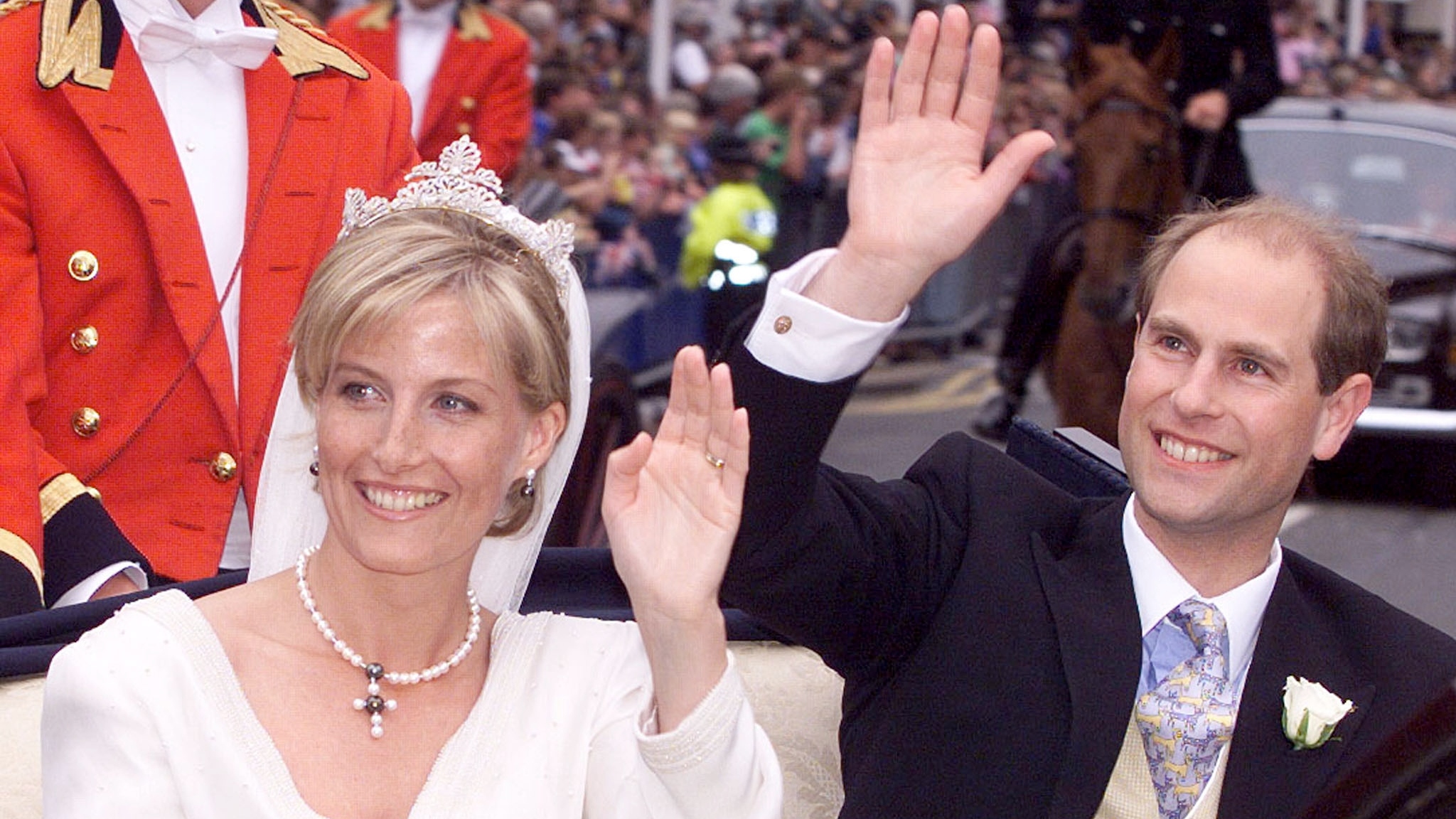 Duke and Duchess of Edinburgh wave as they ride in a carriage after getting married in 1999