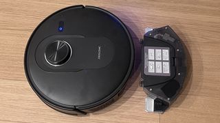 Proscenic Q8 Max robot vacuum with its onboard dust cup removed and placed alongside