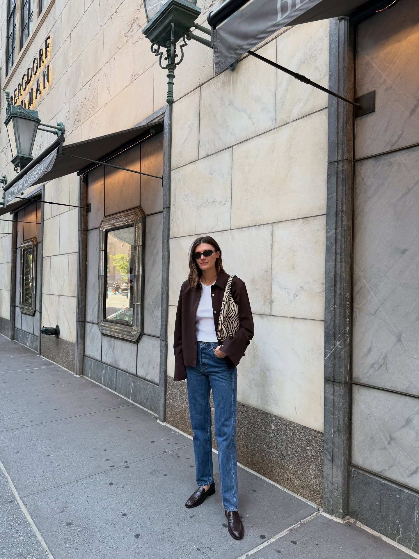 Influencer @cocoschiffer wears cigarette jeans with loafers and a dark brown jacket.