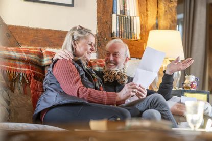 a happy couple reading good news from a statement 