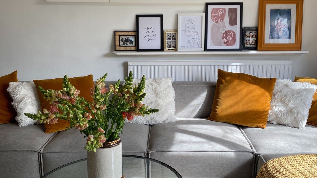 Swyft Model 03 sofa in grey in Annie&#039;s living room with photos on photo shelf behind sofa and flowers on coffee table