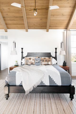 Rustic modern farmhouse bedroom with white walls and wooden ceiling