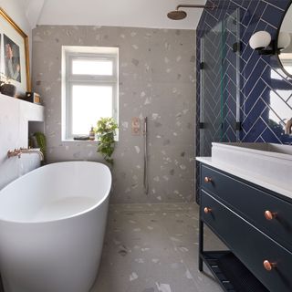 small modern bathroom with walk in shower and blue metro tiles with grey patterned floor tiles