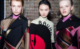 Models wear block-coloured outerwear, with 'Bauhaus' text written over