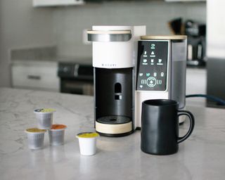 Bruvi coffee maker on modern white marble worktop with black cup and B-pods