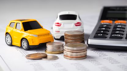 Cars and coins with calculator on financial statement