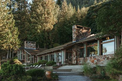 morse house in vancouver, the modernist home's stone and wood exterior among trees