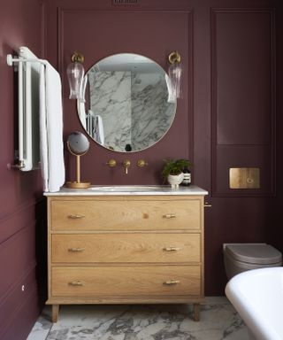 Burgundy bathroom micro trend, dark red walls surrounding a bath tub