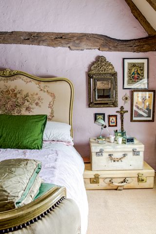 French-style bedroom with light pink wall and suitcase bed side table