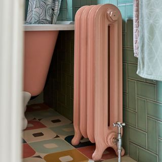 Pink painted radiator in bathroom with patterned tiles