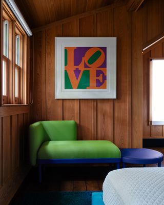 a bedroom with a bold blue and "Brat Green" chaise