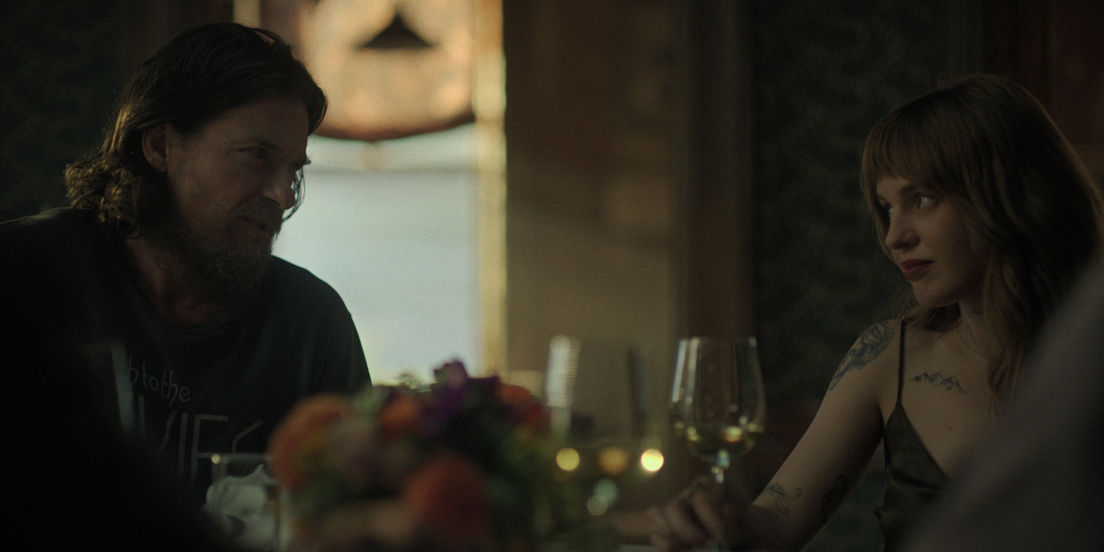 jason bateman as vince and odessa young as gen talking over dinner in black rabbit