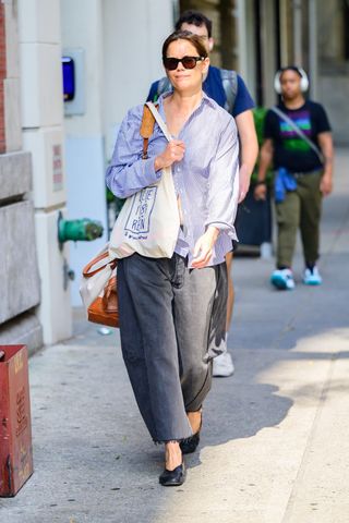 Katie Holmes is pictured while out running errands this morning, wearing a striped dress shirt, barrel jeans, and black flats. Sept. 19