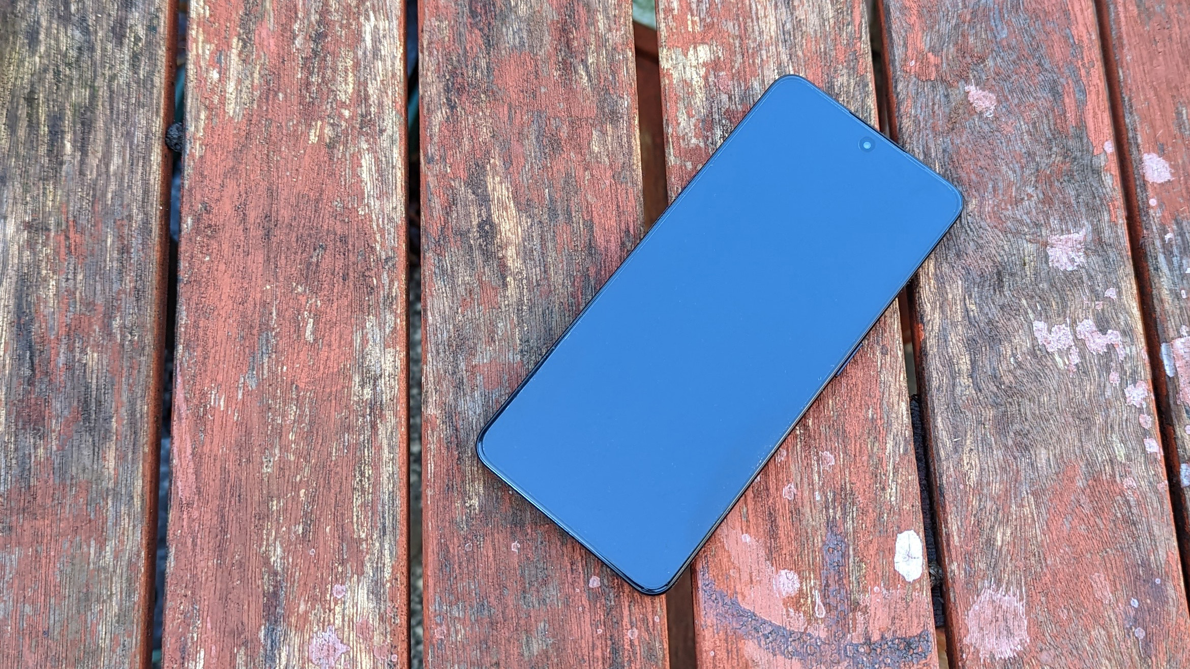 An Oppo Reno 8 Pro smartphone on a rustic table