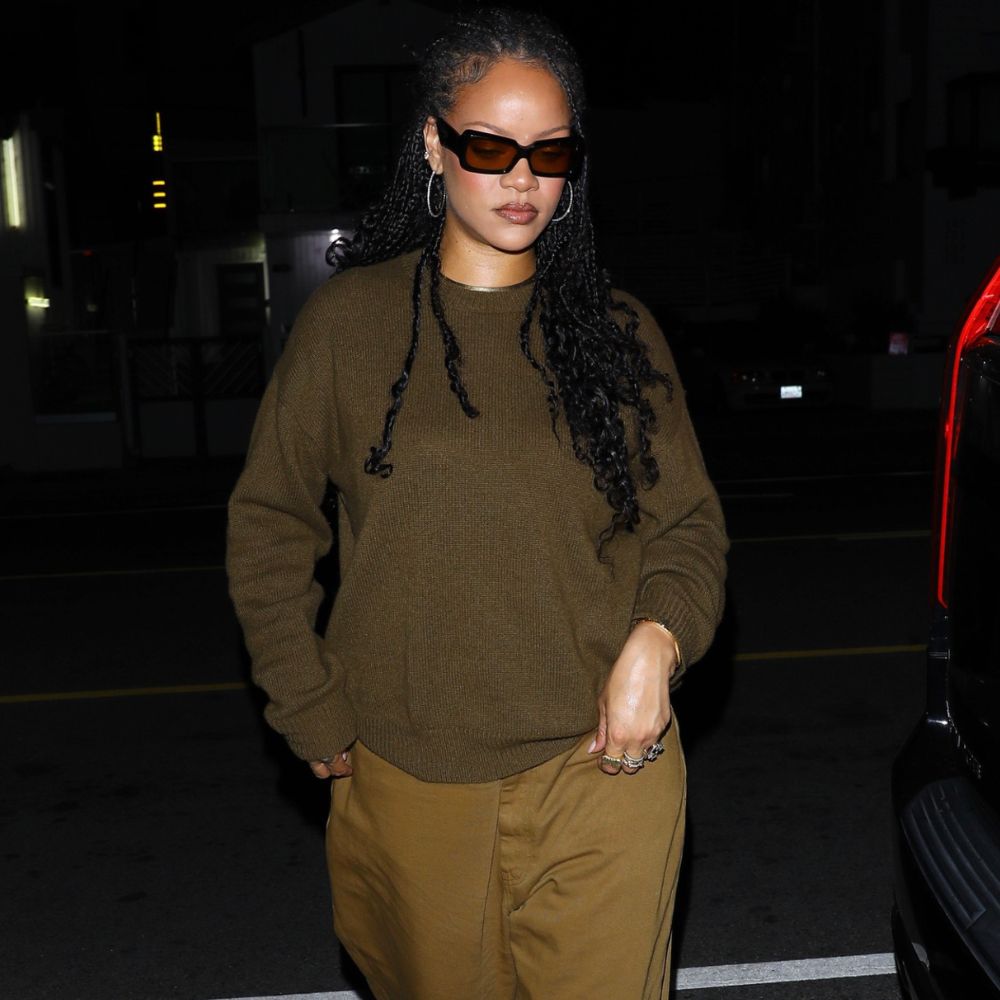 Rihanna steps out at night wearing a khaki jumper with khaki jeans and black ballet flats.