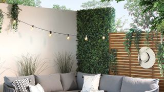small patio with modern fence and rendered wall and fairy lights