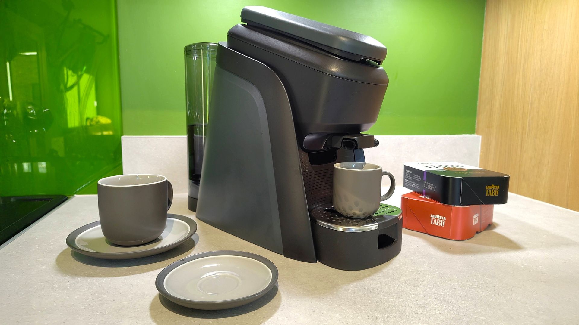 Lavazza Tabli coffee maker on kitchen counter with coffee cups and coffee tabs