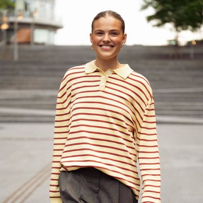 street style shot of woman in striped polo top wearing minimal makeup
