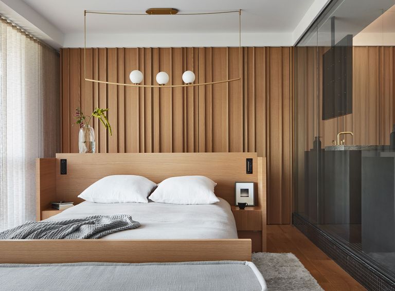 a bedroom with a headboard dividing the room from the closet