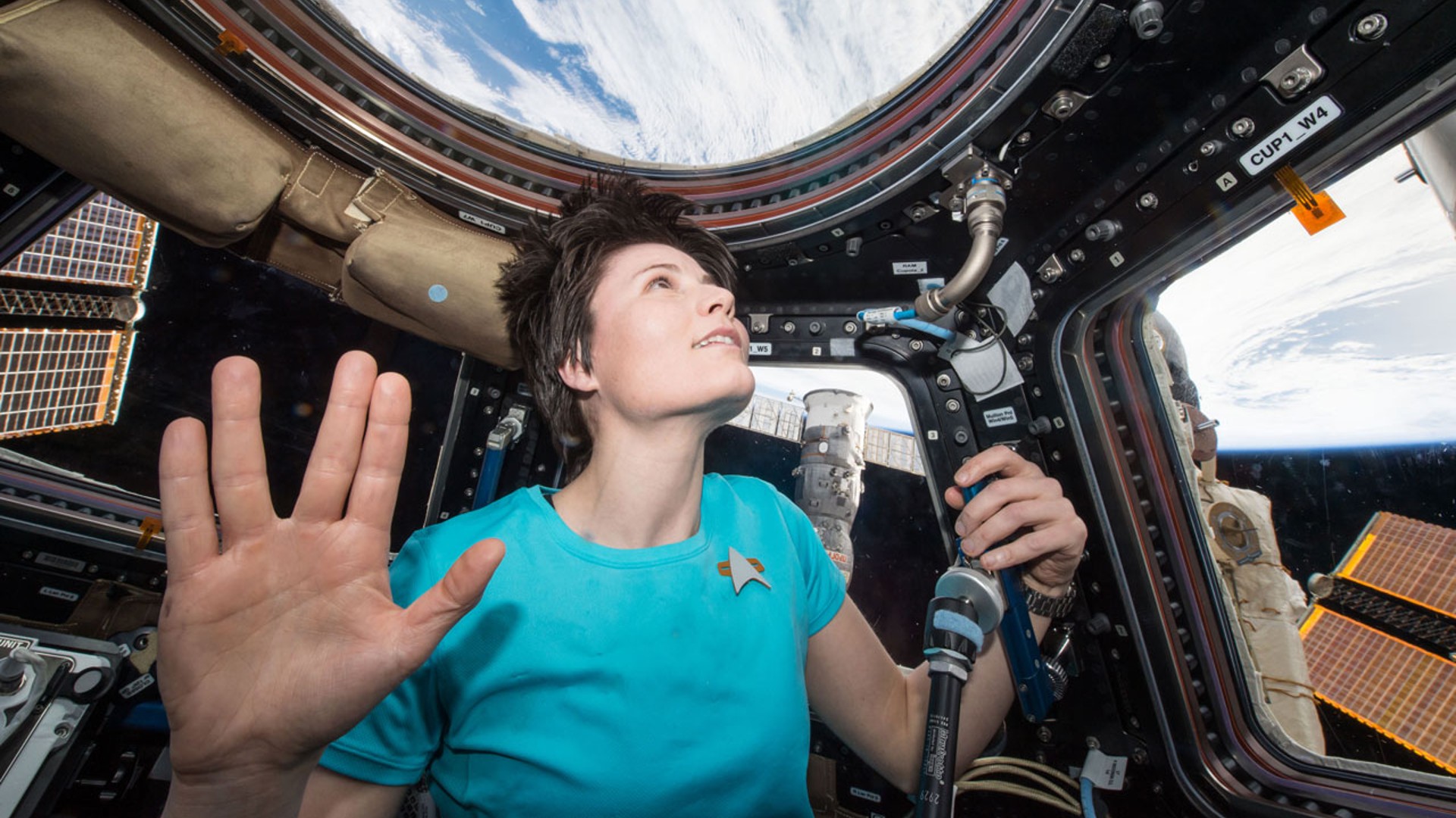 samantha cristoforetti looking out a window with the vulcan salute
