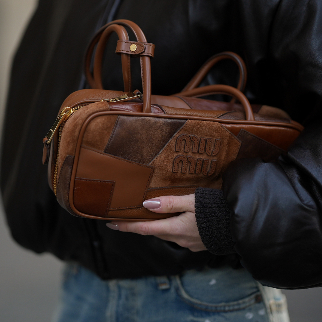 Nail Trends Romina Meier is seen wearing a dark brown bomber jacket with a coated leather finish, zip closure and classic collar from Acne Studios; distressed and painted wide-leg light-wash denim jeans from Acne Studios; a cognac brown Miu Miu Beau Patchwork leather handbag with patchwork pattern in different shades of brown from Miu Miu on November 10, 2025 in Duesseldorf, Germany