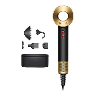 Dyson Supersonic hairdryer with parts and housing against a white background