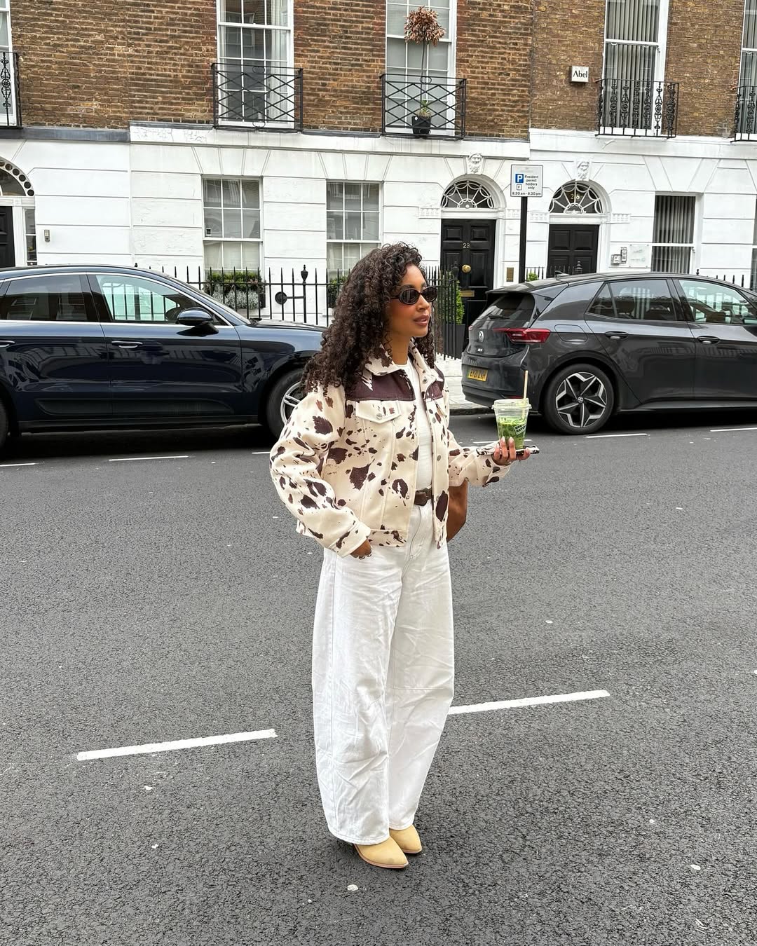 @laylaabbey wears white jeans cow print jacket