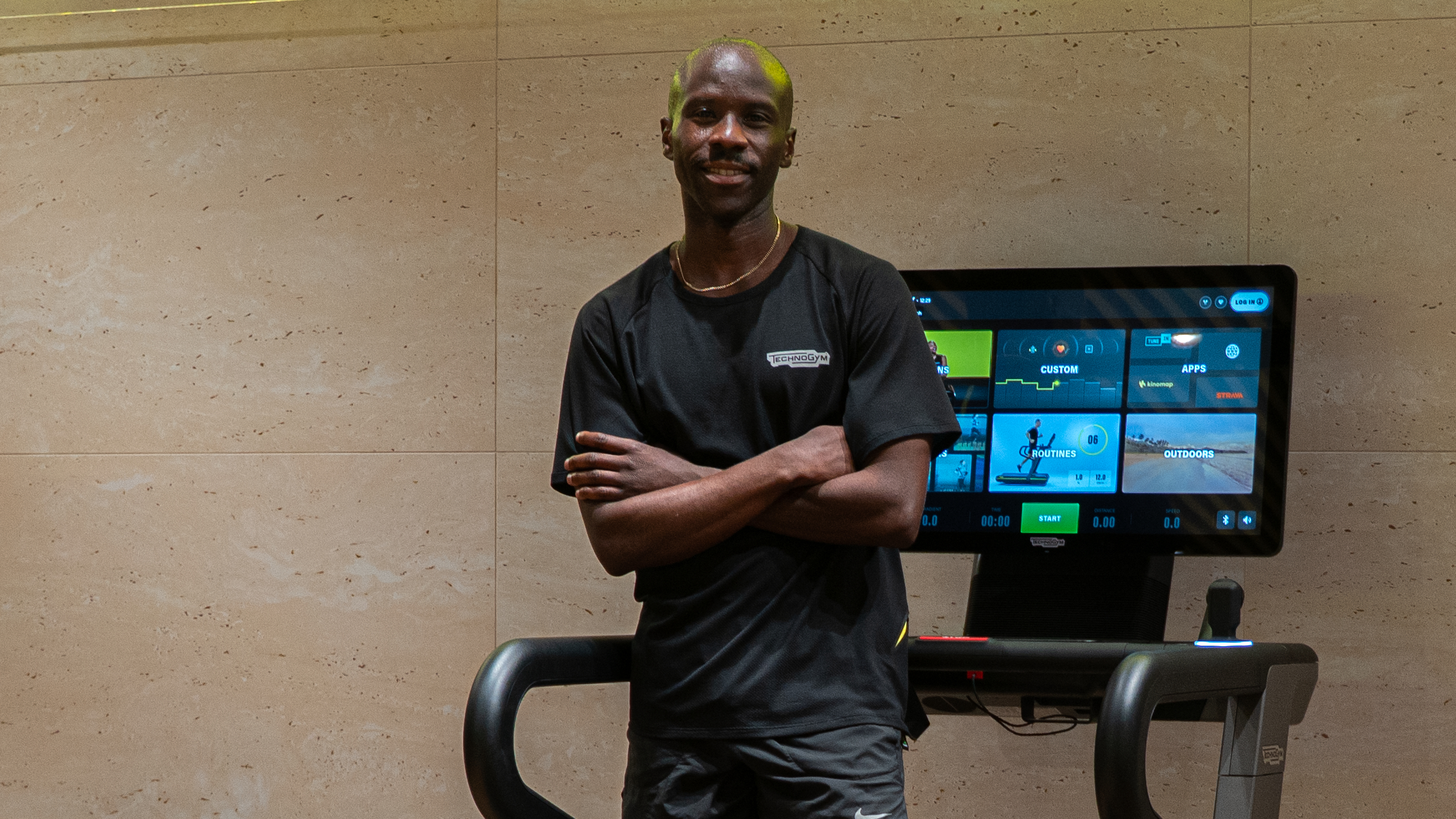 Man standing on treadmill with arms folded looking at camera