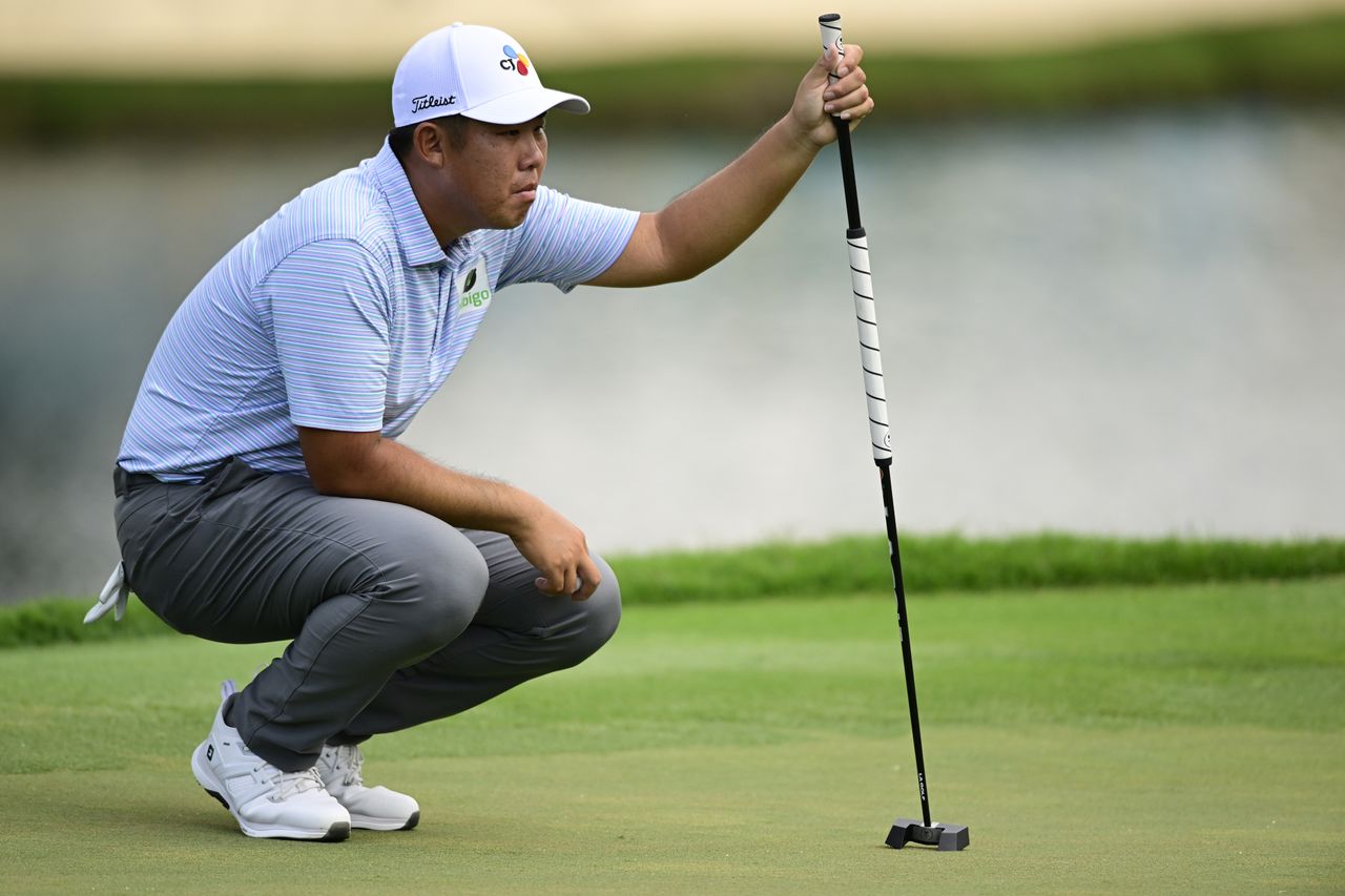 Byeong Hun An lines up a putt