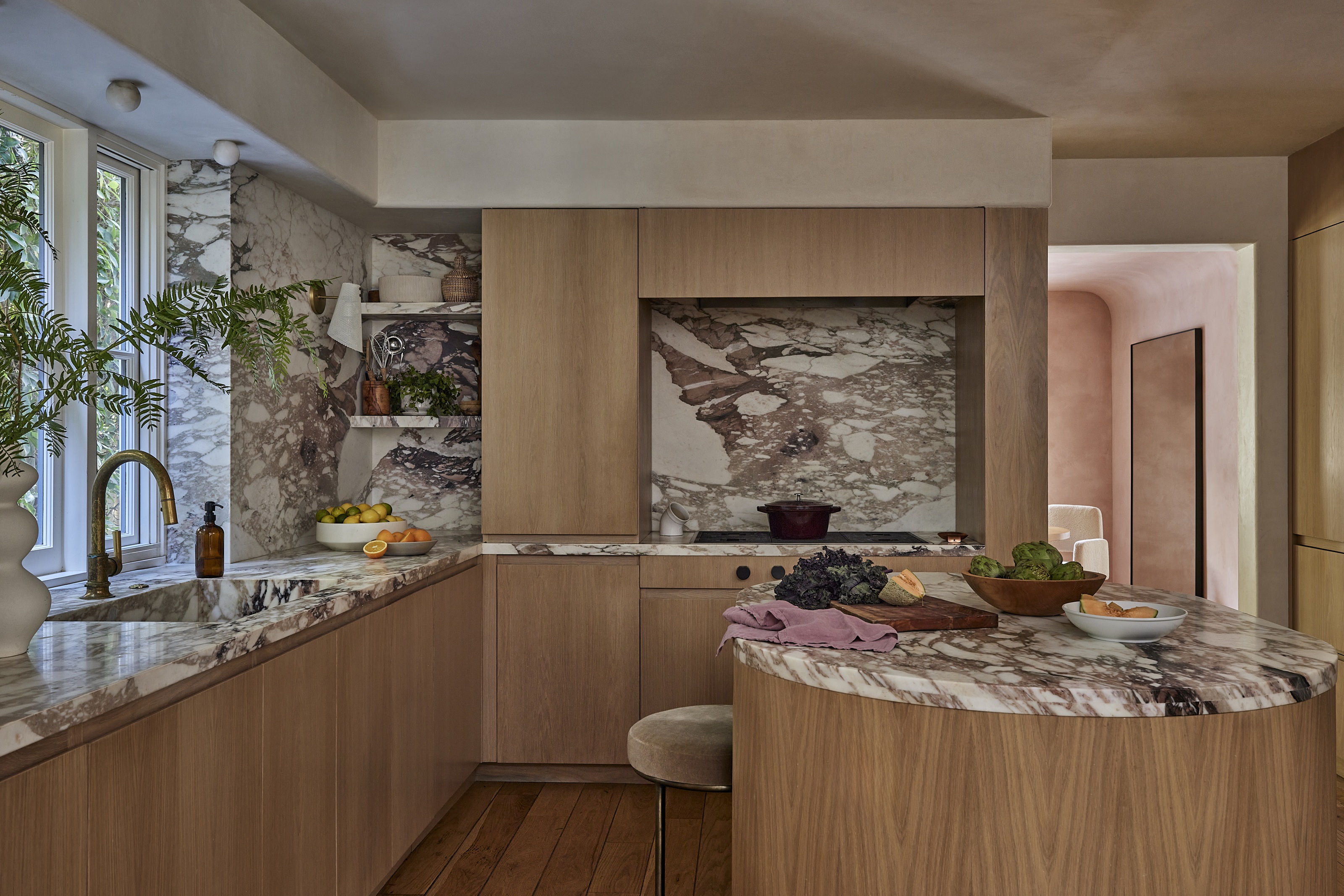 a wood and marble kitchen with a round island