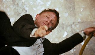 Quantum of Solace Daniel Craig aims his gun upward to fire