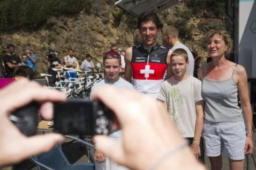 A person takes a picture of Switzerland's four-time world champion Fabian Cancellara (3rdR) and fans at his hotel