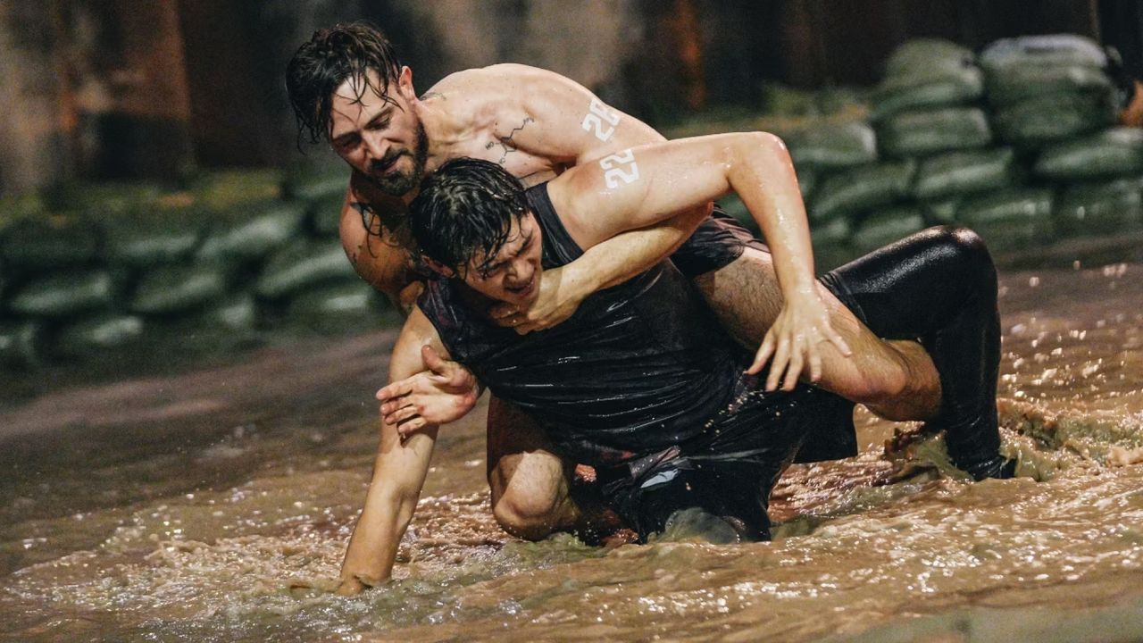 two men (justin harvey and another contestant) wrestle in a pit of shallow water, in &#039;physical 100&#039; season 2